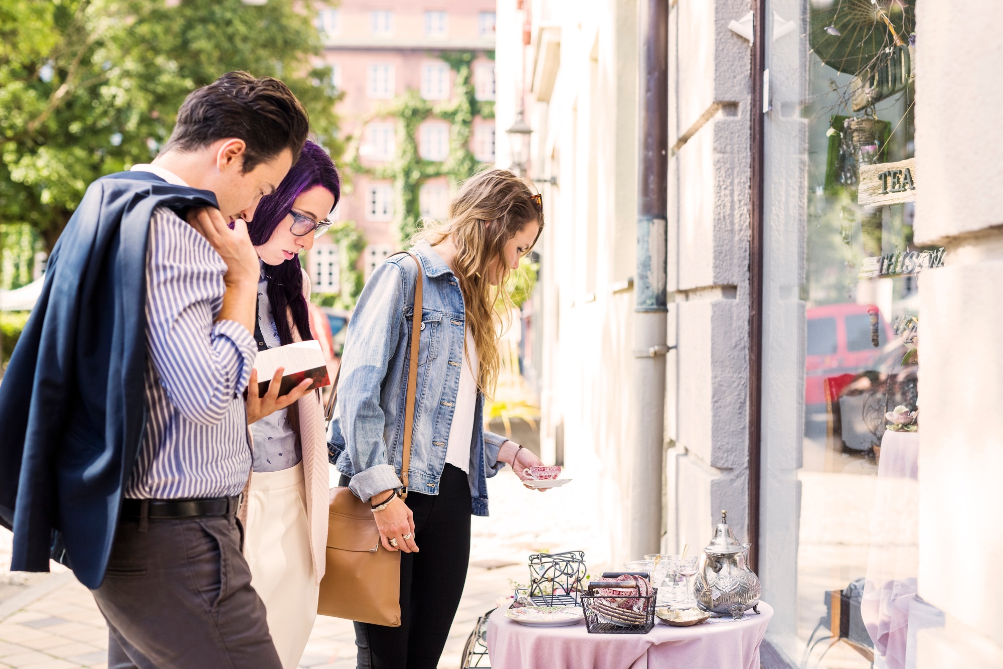 Friends selecting crockery outside store