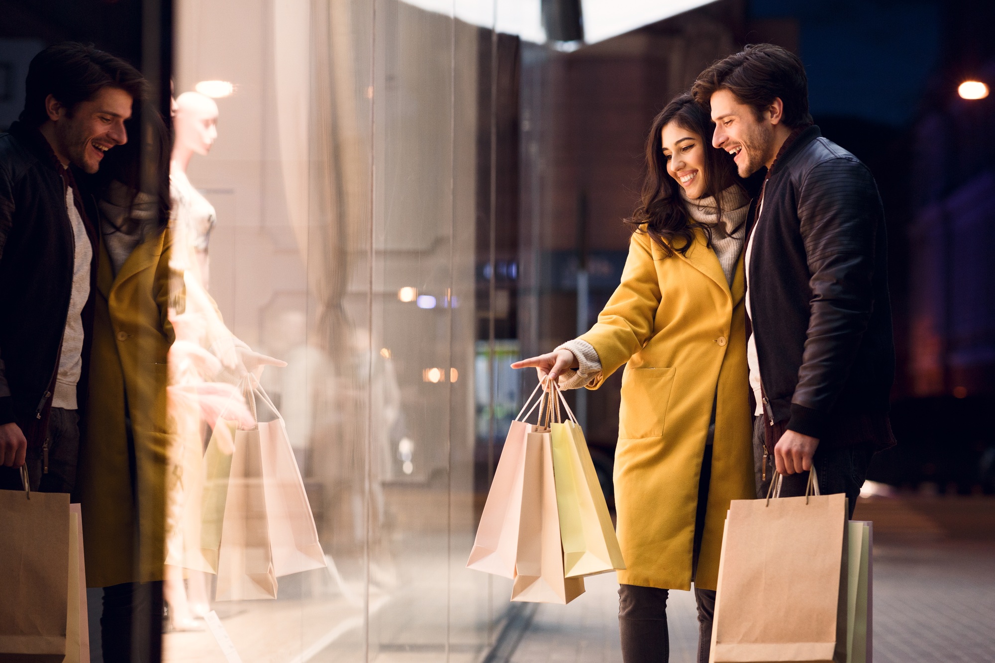 Window shopping. Couple looking at fashion store's showcase