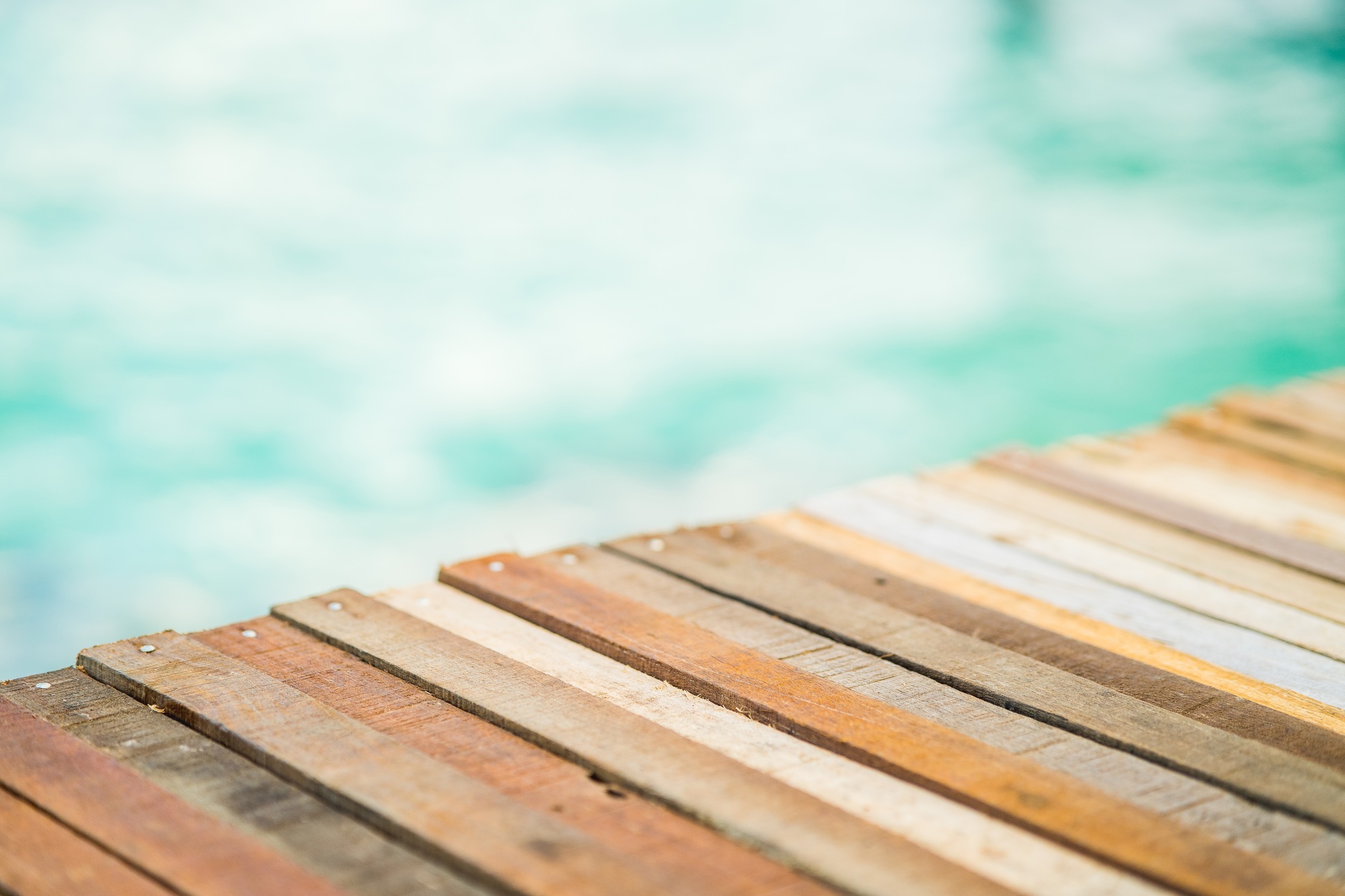 wooden deck against turquoise sea water